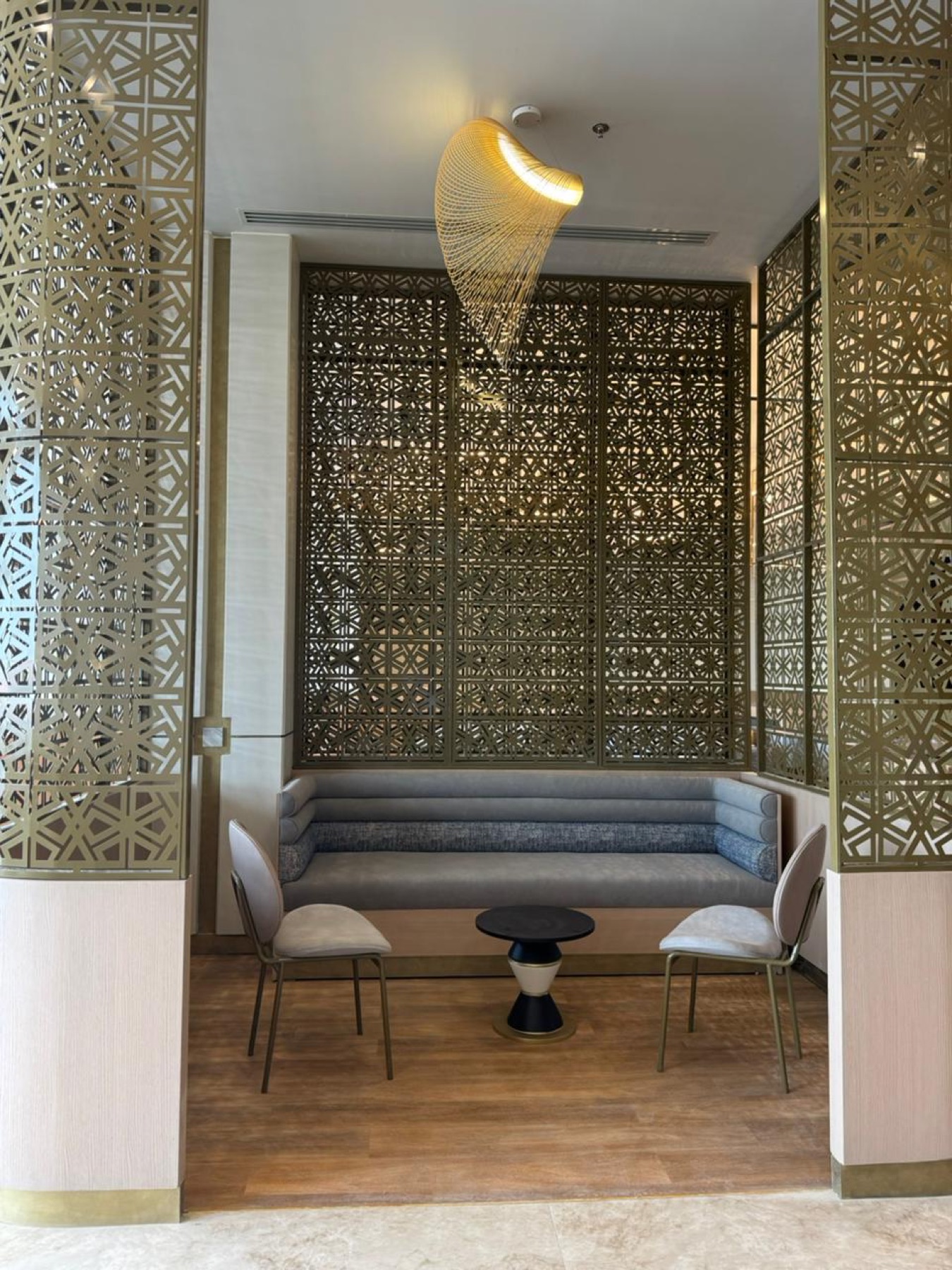 Private booth wrapped in golden mashrabiya latticework