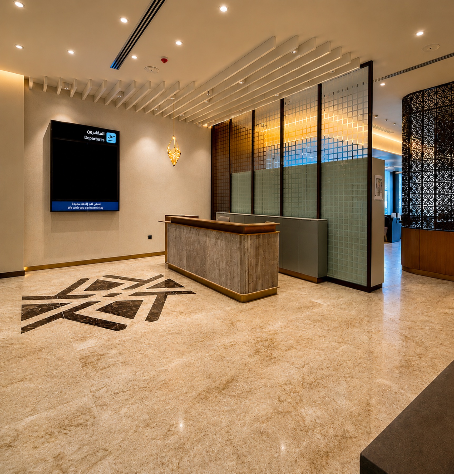 Reception desk with patterned marble floor and departure screens